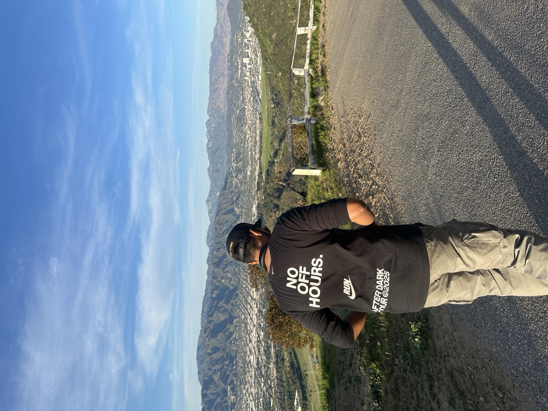 Aditya hiking above Los Angeles wearing a 'No off hours' t-shirt